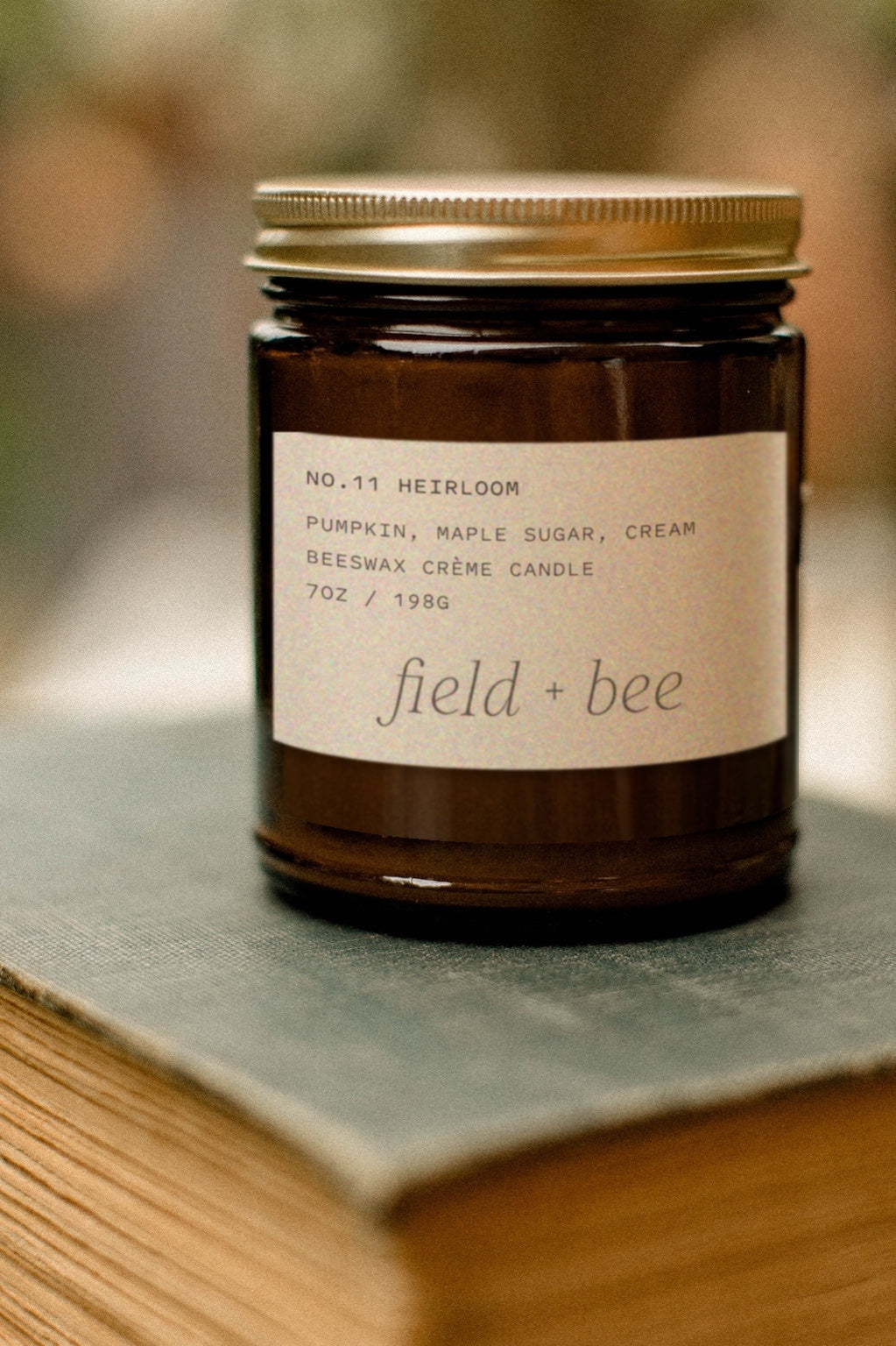 Field + Bee No. 11 Heirloom candle in amber glass jar with gold lid